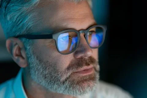Focused Man with Glasses Working on Computer in Low Lighting Stock Photos