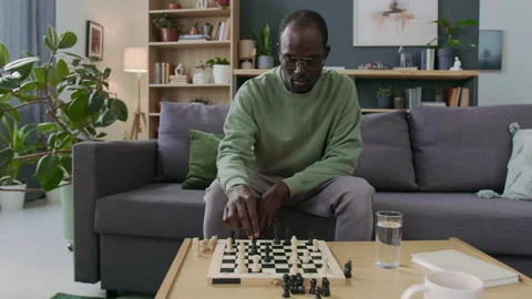 Focused Man Playing Chess against Himself during Practice at Home Stock Footage 290467533