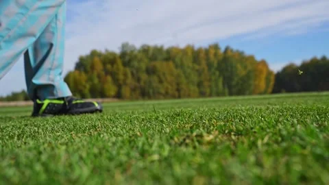 Focused man practicing golf swing on driving range with greenery in background Stock Footage 346360415
