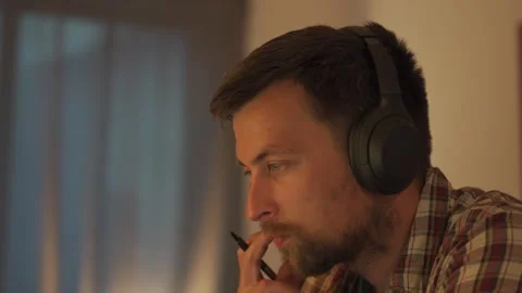 Focused man in professional headphones learning online, concentrating on a web Stock Footage 323612802