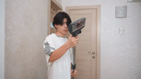 Focused man setting up vacuum for cleaning. Person methodically assembling Stock Footage 345536474