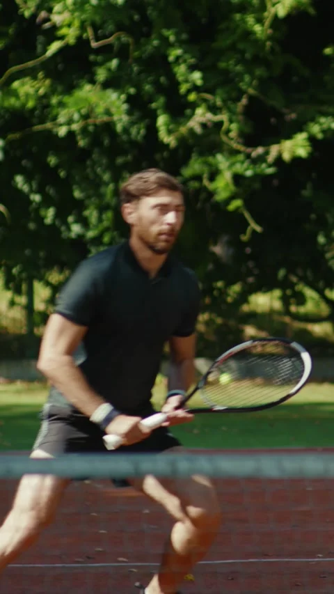 A focused man showcases his athleticism on a vibrant tennis court 動画素材 316513359