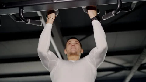 Focused Man Training Hard Doing Pull-Ups in a Modern Gym Stock Footage 274054941