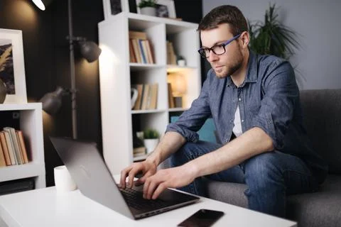 Focused man using laptop for remote work Foto stock