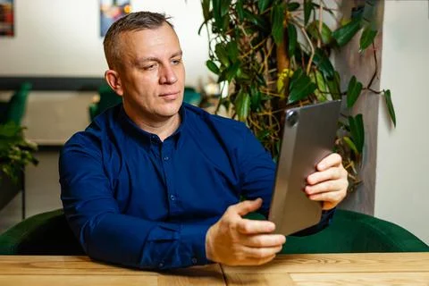 Focused Man Using Tablet in Modern Workspace Stock Photos