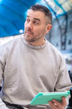 Focused Man Using Tablet While Waiting at Train Station looking at camera Stock Photos