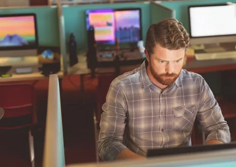 Focused man working on computer in modern office, concentrating on task, copy Foto stock
