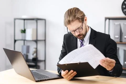 Focused man working with documents at office Stock Photos