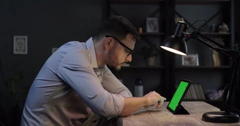 Focused man working on green screen digital tablet at home office. Concentrated Stock Footage 276843086