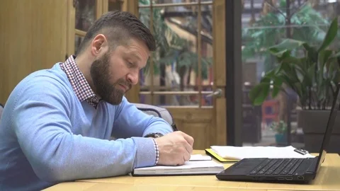 Focused man working, making notes from laptop computer. cafe, profile steadicam Vídeo Stock 73072762