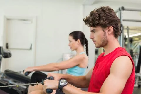 Focused man working out on the rowing machine Stock Photos