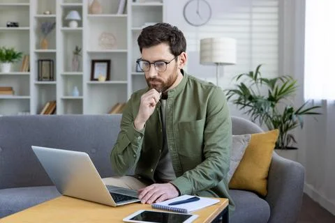 Focused man working remotely from a stylish home office 库存照片