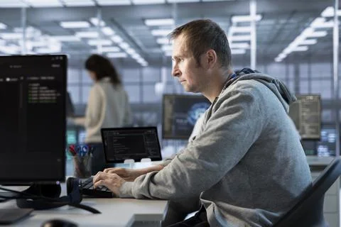 Focused man working in server farm capable of processing vast amounts of data Foto stock