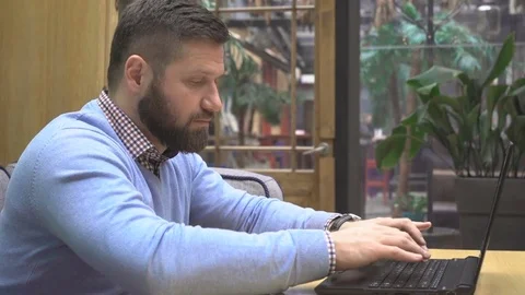 Focused man working, writing on laptop computer, shows ok at camera, steadicam 库存影片 73072708