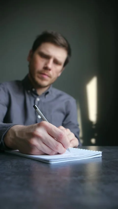 Focused man writing notes in a notebook Vidéo 337892355