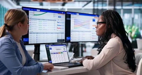 Focused Manager Uses Laptop To Track Grant Funding And Donation Impact. Stock Photos