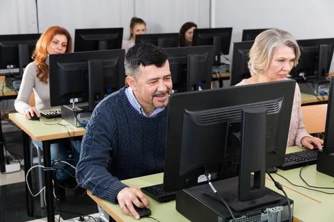 Focused mature man during computer classes Stockfoto's