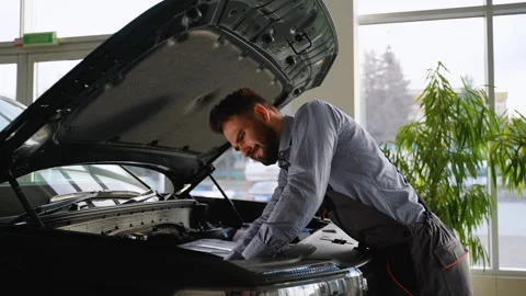 Focused mechanic repairing car engine in modern service center Stock Footage 300613557