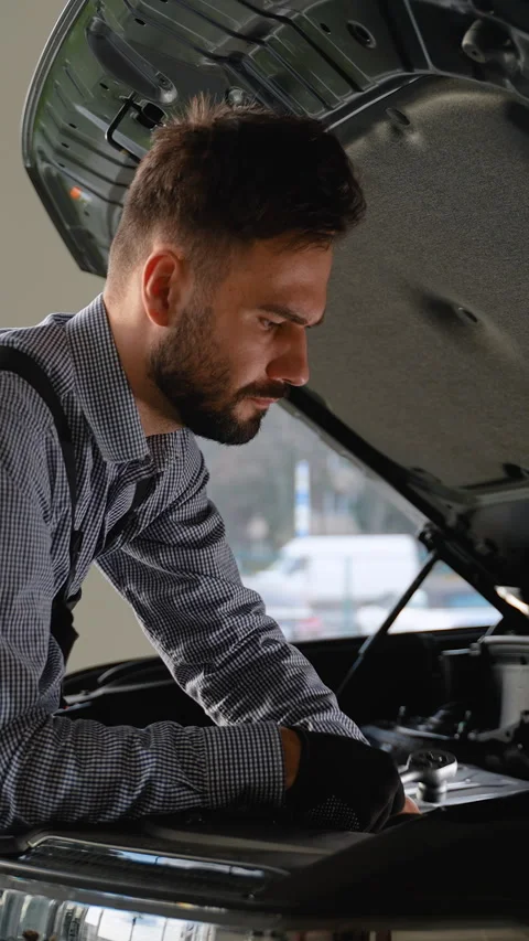 Focused mechanic repairing car engine in modern service center Stock Footage 300615114