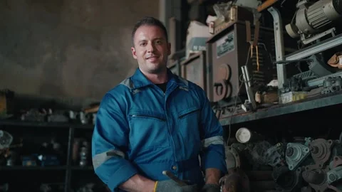 Focused mechanic stands in cluttered workshop Stockbeeldmateriaal 345031732