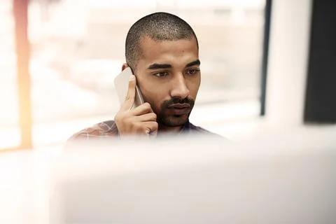 Focused on meeting his commitments. a young entrepreneur talking on a cellphone Stock Photos