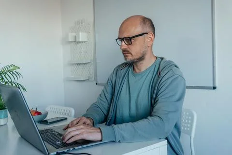 Focused Middle Aged Man Working On Laptop At Home Stock Photos