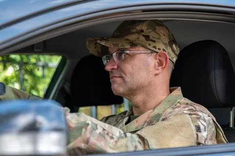 Focused military driver sitting inside vehicle wearing camouflage uniform Stock-Fotos