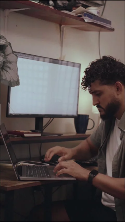 Focused millennial entrepreneur using mobile phone and laptop Stock Footage 341498091