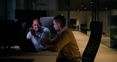 Focused multicultural team collaborating late at night, analyzing data and Stock Footage 305590242