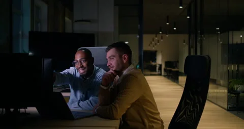 Focused multicultural team collaborating late at night, analyzing data and Stock Footage 305591365