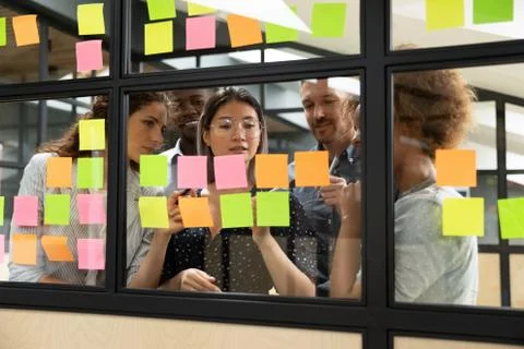 Focused multiethnic business team brainstorm with sticky notes in office Stock Photos
