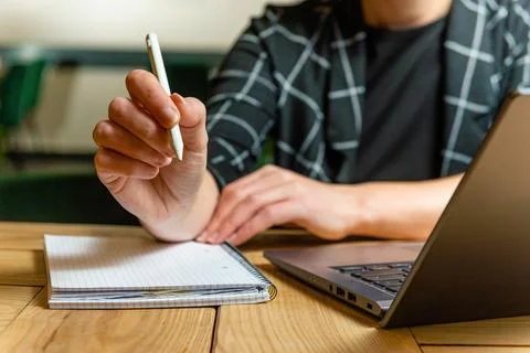Focused Note-Taking with Laptop in Modern Workspace Stock Photos
