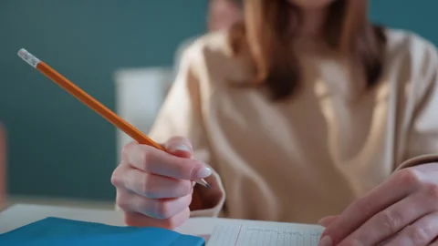 Focused notetaking effort. Person diligently taking notes on grid paper while Stock Footage 336865920