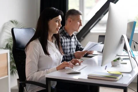 Focused Office Team Working On Computer And Analyzing Documents Stock-Fotos