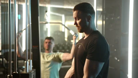 Focused Pair on Cable Crossover Training in Bright Gym Stock Footage 269206812