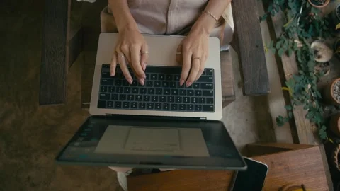 A Focused Pair of Hands Swiftly Typing on a Laptop While Seated Outdoors in Stock-Footage 280848556