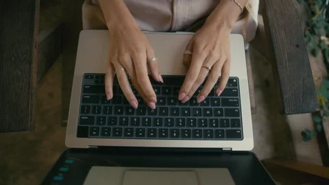 A Focused Pair of Hands Swiftly Typing on a Laptop While Seated Outdoors in Stock Footage 280848596