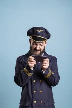 Focused plane pilot gaming on smartphone in landscape mode 写真素材