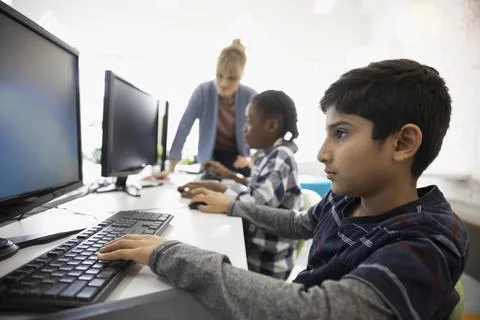 Focused pre-adolescent boy using computer in classroom Stock Photos