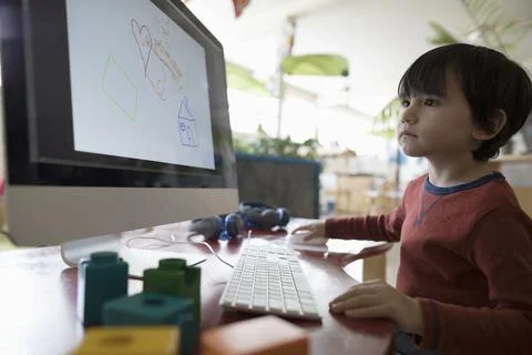 Focused preschool boy drawing with computer Stock Photos