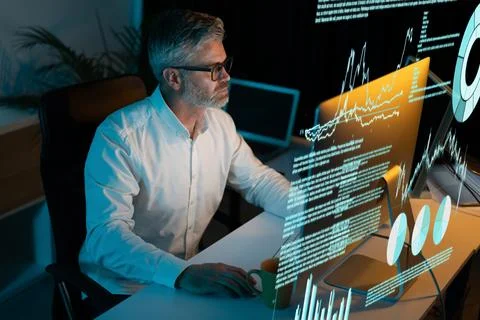 Focused Professional Analyzing Data on Computer in Modern Office Environment Stock Photos