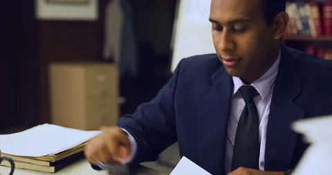 Focused professional black man stamping stack of paper frantically in interior l Stock Footage 199456312