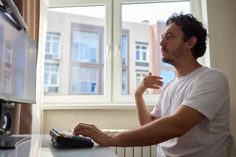 A Focused Professional Engaged in Work from Home in a Cozy Environment While 写真素材