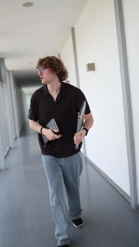 Focused professional reviews work while walking with laptop Stock Footage 337850059