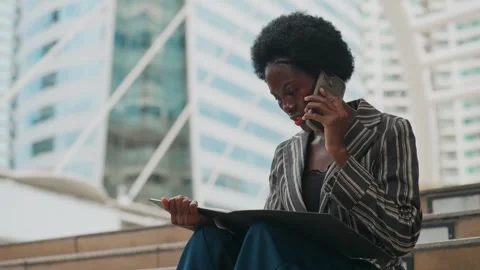 Focused professional talks on phone while reviewing documents Vídeo Stock 345198686