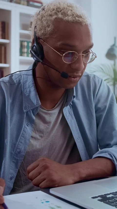 Focused professional wears headset talks and takes notes while online conference Stock Footage 335974703