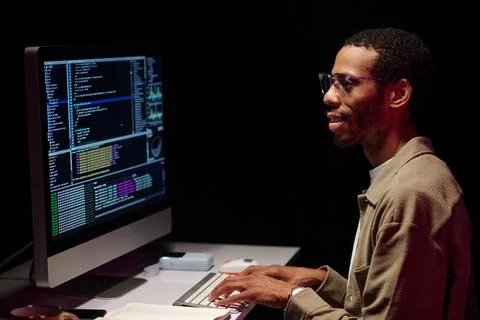 Focused Programmer Analyzing Code on Computer Screen Foto stock