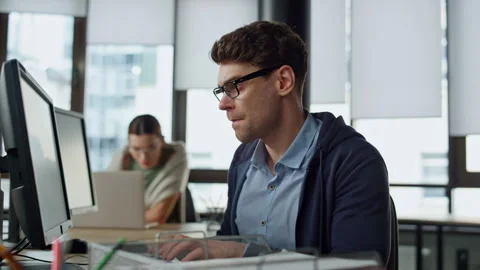 Focused programmer checking code at desk. It guy professional solving problem Stock Footage 242983914