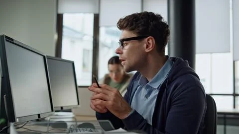 Focused programmer checking code at desk. It guy professional solving problem Stock Photos