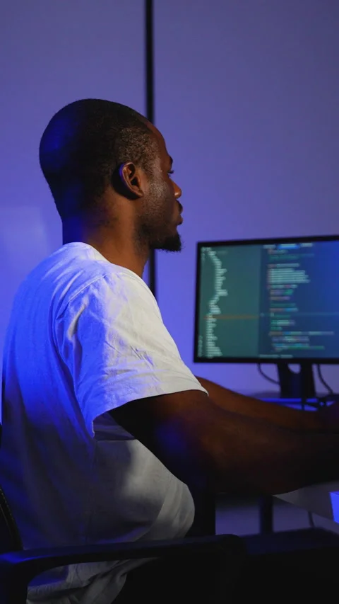 Focused programmer coding on multiple screens at night Stock Footage 305022583